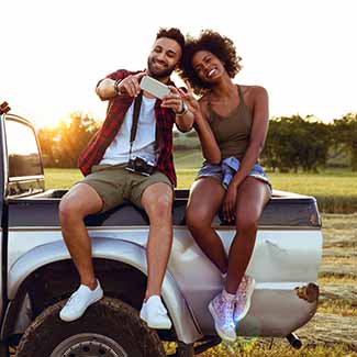 Young couple sitting on pickup truck